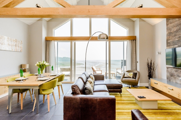 A living room with French doors that show views of the seaside