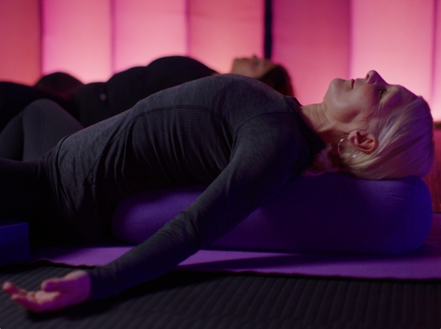 Two women lying on the floor in a yoga pose