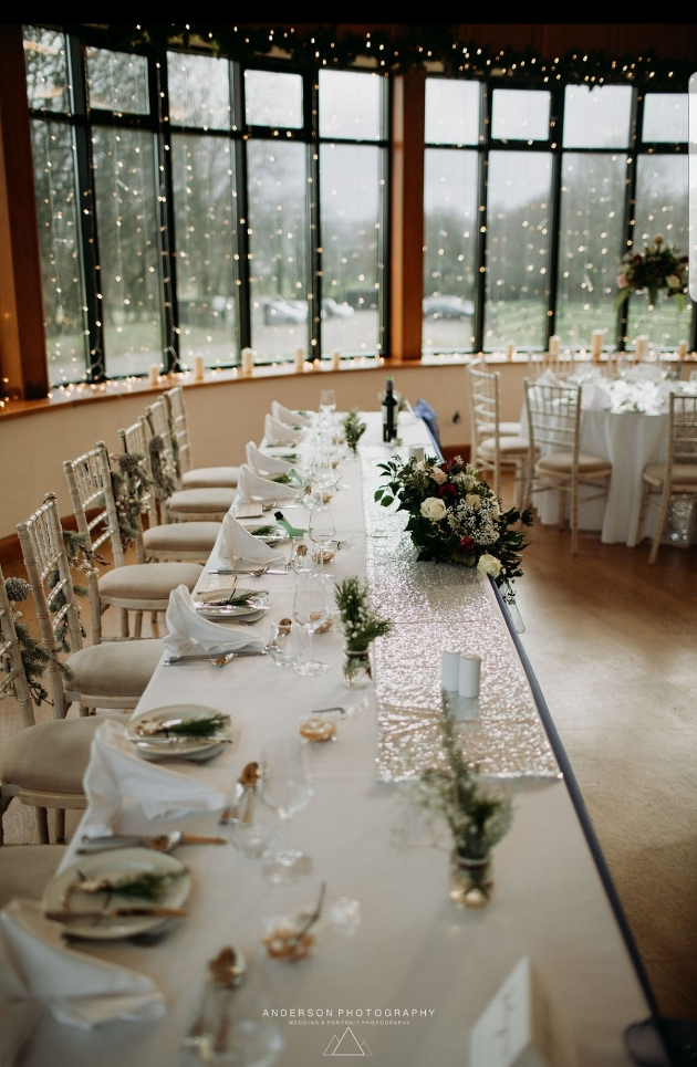 A long table decorated with flowers and fairylights