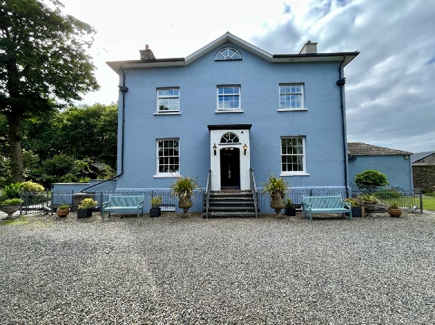 A blue building sitting on a paved courtyard