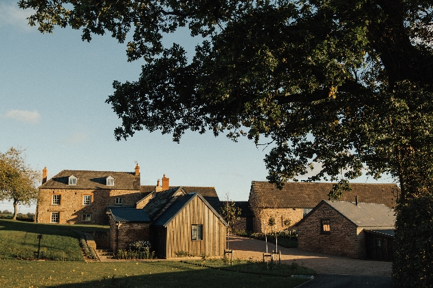 Several farm buildings and houses surrounded by grass and trees