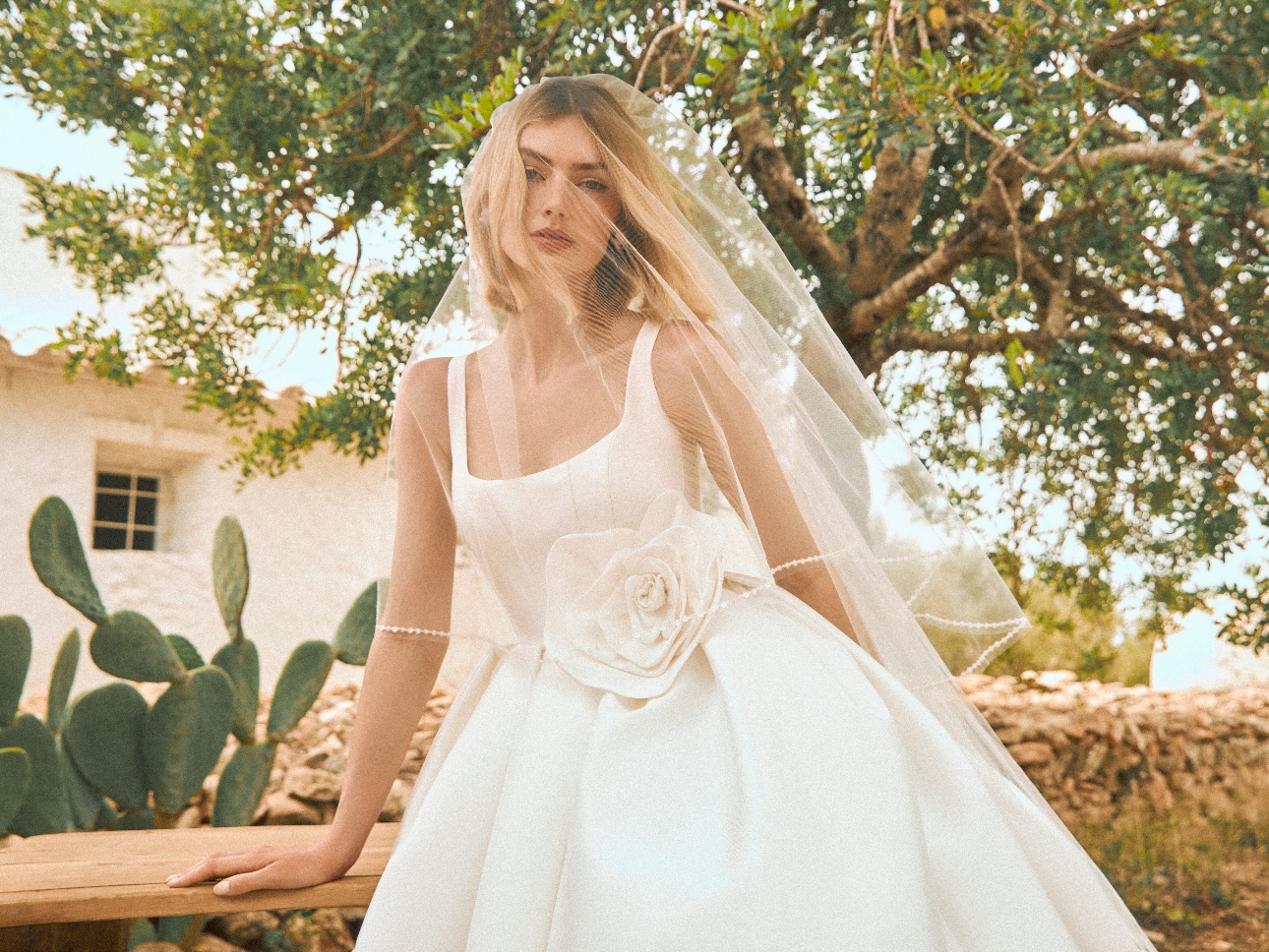 bride in square nexk corset-style dress with big flower between bodice and skirt