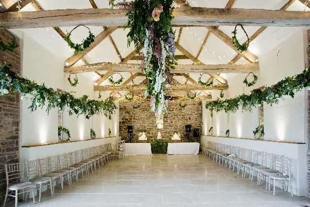 A large room with brick walls and wooden beams decorated with flowers