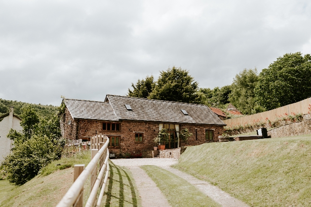 The exterior of a barn surrounded by manicured grounds