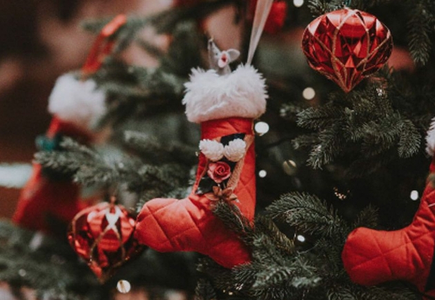 Several red stockings hanging from a Christmas tree