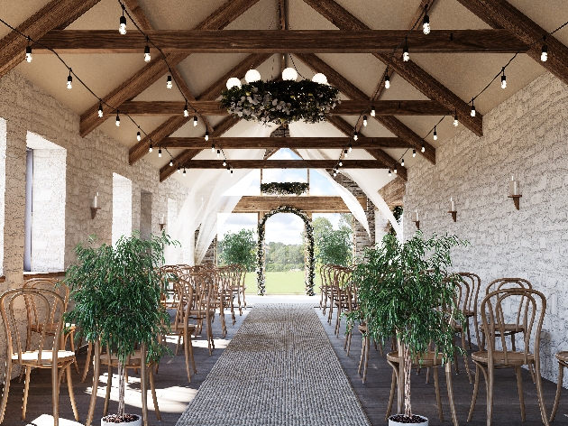 A light-filled room with stone walls and dark beams with large windows at the end of the aisle